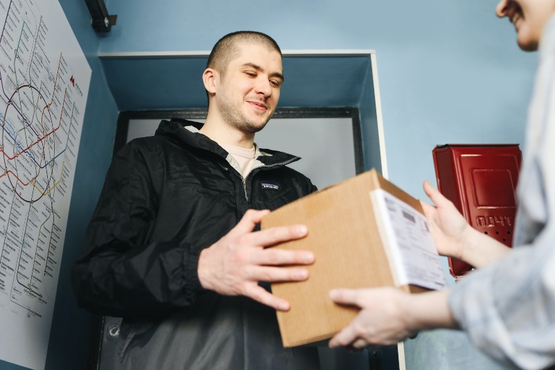 shot of a customer receiving a package and smiling